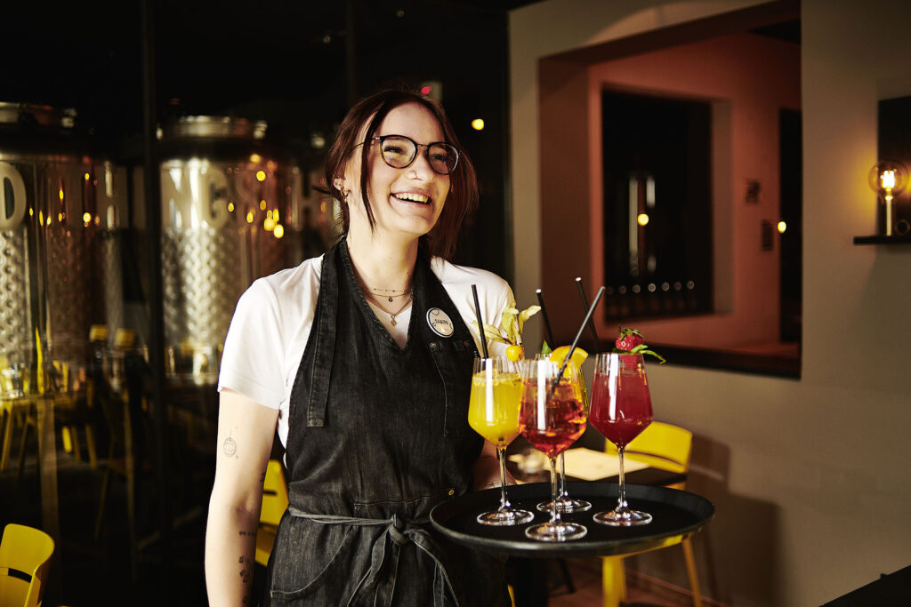 Kellnerin mit Tablett auf dem Aperitifs stehen